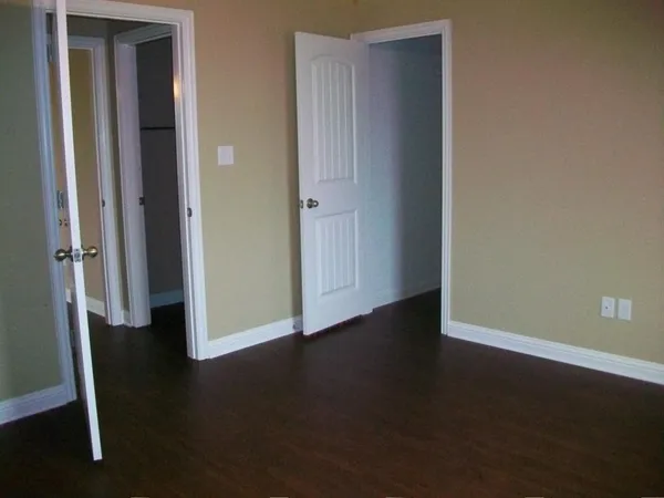 an empty room with wooden floor and closet