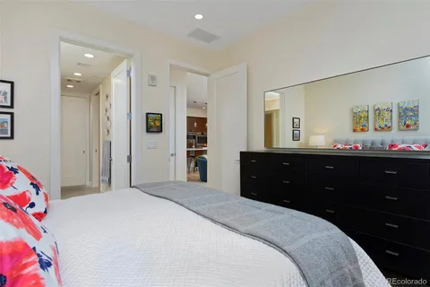 a bedroom with a bed and a mirror on dresser