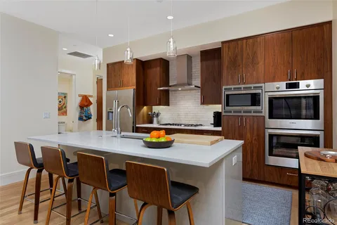 a kitchen with stainless steel appliances a dining table and chairs