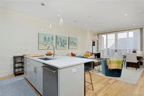 a view of kitchen with stainless steel appliances granite countertop a sink a stove and wooden floor
