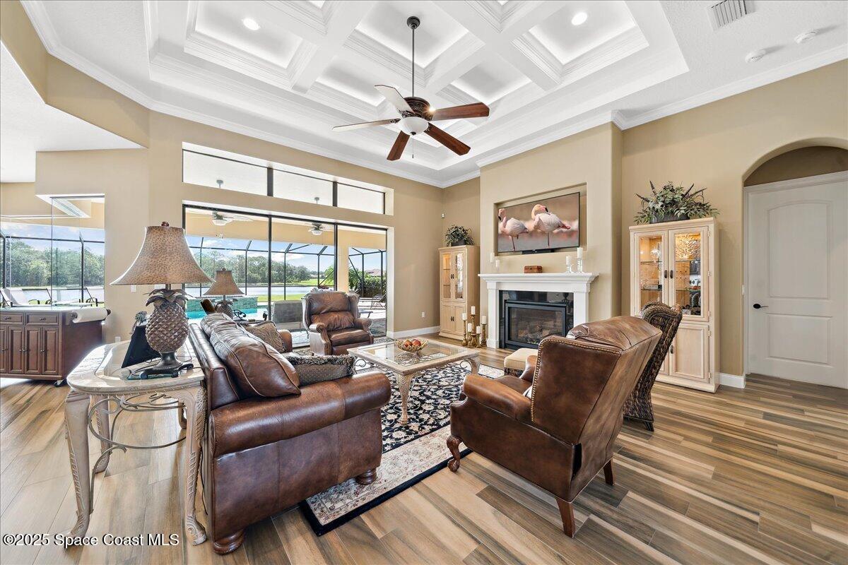 4464 Preservation Circle Melbourne, FL 32934 - Photo 15 of 65 a living room with furniture a ceiling fan fireplace and a large window