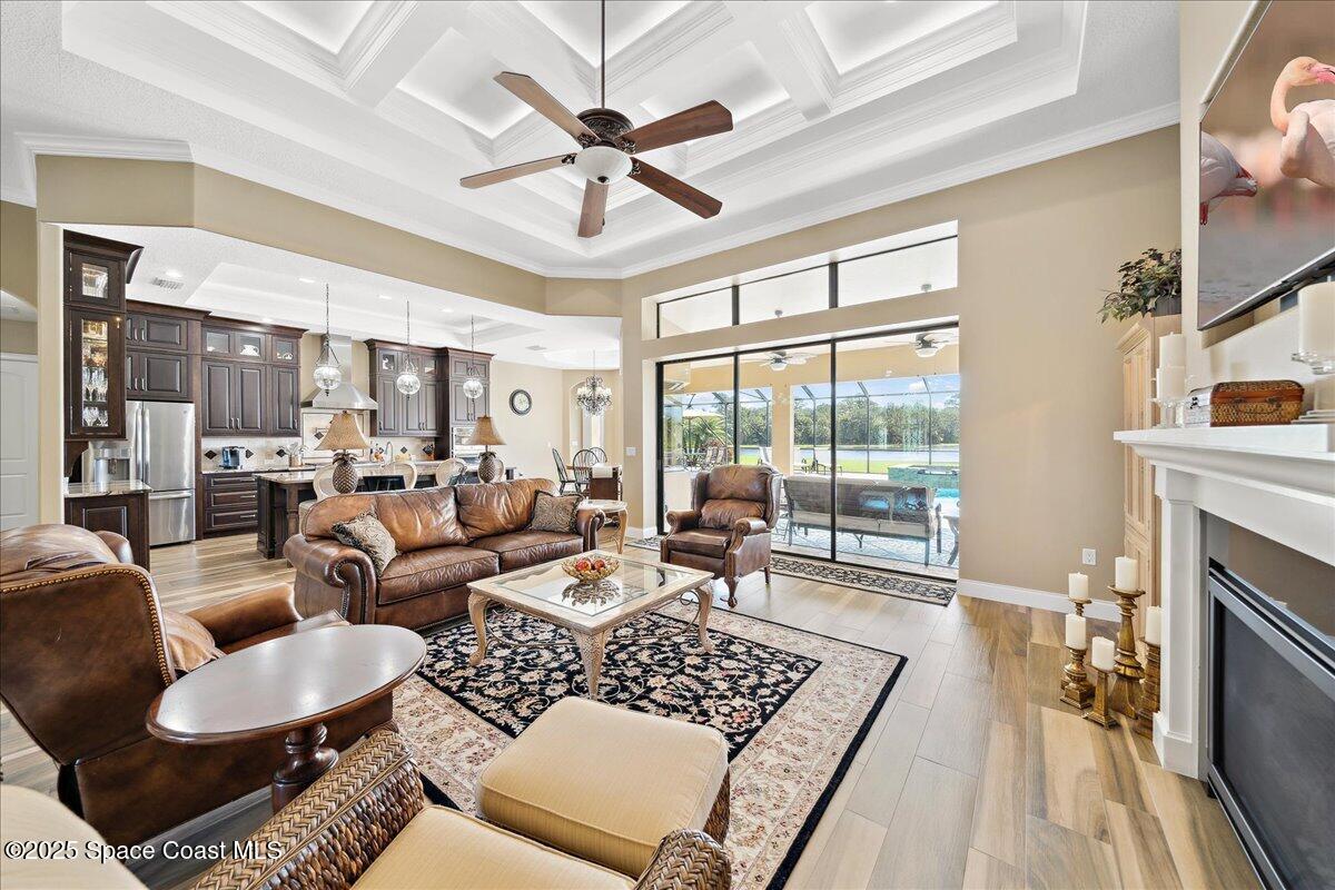 4464 Preservation Circle Melbourne, FL 32934 - Photo 17 of 65 a living room with furniture a fireplace and a floor to ceiling window
