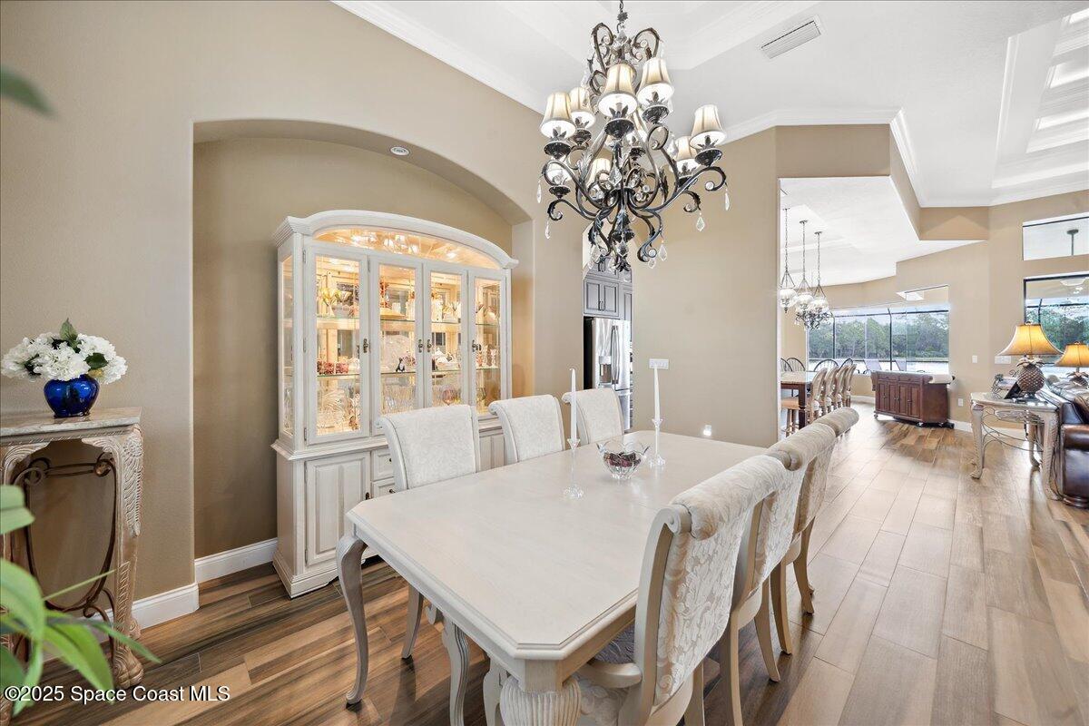 4464 Preservation Circle Melbourne, FL 32934 - Photo 19 of 65 a view of a dining room with furniture a chandelier and wooden floor
