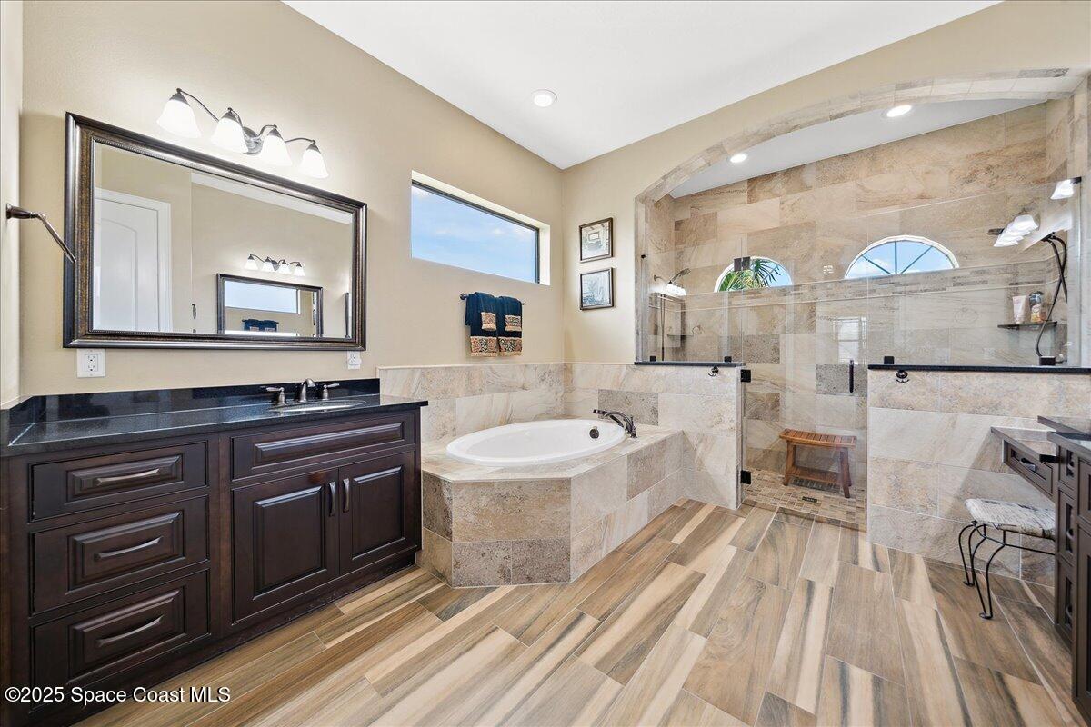4464 Preservation Circle Melbourne, FL 32934 - Photo 23 of 65 a spacious bathroom with a bathtub shower sink and mirror