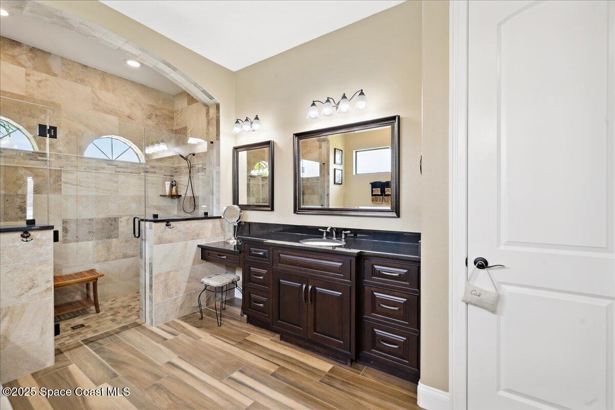 4464 Preservation Circle Melbourne, FL 32934 - Photo 24 of 65 a spacious bathroom with a double vanity sink and a mirror
