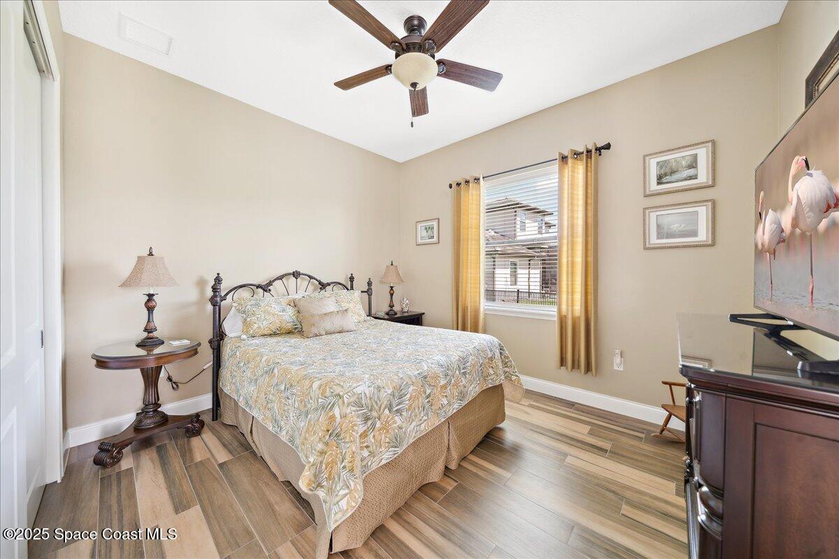 4464 Preservation Circle Melbourne, FL 32934 - Photo 29 of 65 a bedroom with a bed and a chandelier