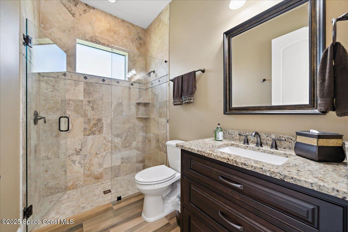 4464 Preservation Circle Melbourne, FL 32934 - Photo 31 of 65 a bathroom with a granite countertop sink a toilet and shower