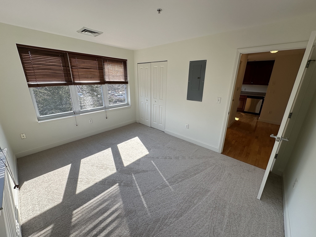 318 Rindge Avenue, Unit 216 Cambridge, MA 02140 - Photo 12 of 15 a view of an empty room with windows