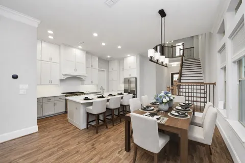 a kitchen with stainless steel appliances kitchen island granite countertop a stove a sink a dining table and chairs