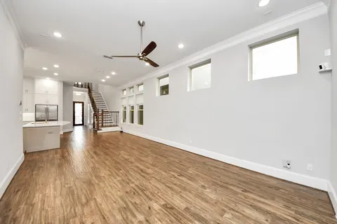 a view of a kitchen with a dishwasher and white cabinets with wooden floor