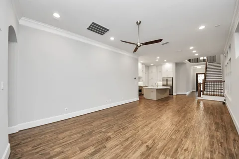 a view of an empty room with window and wooden floor