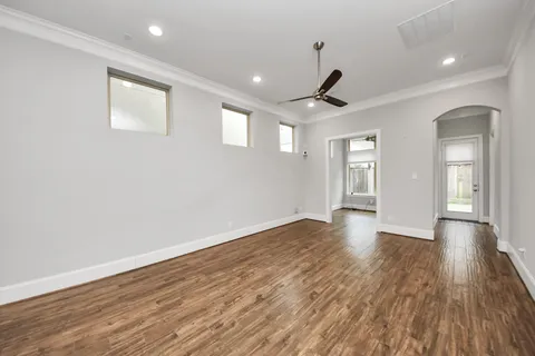 a view of an empty room with wooden floor and window