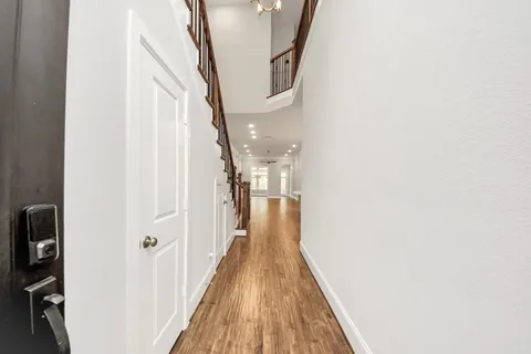 a view of a hallway with wooden floor and staircase
