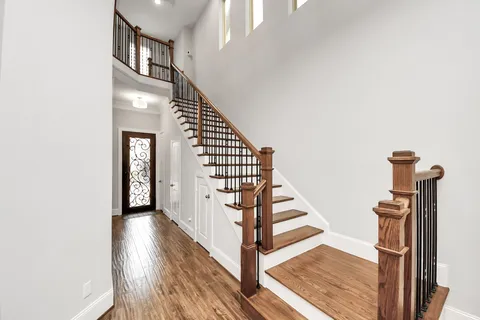 a view of a hallway with wooden floor and entryway