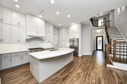 a kitchen with a sink and wooden floor