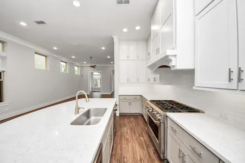 a kitchen with a sink a stove and cabinets