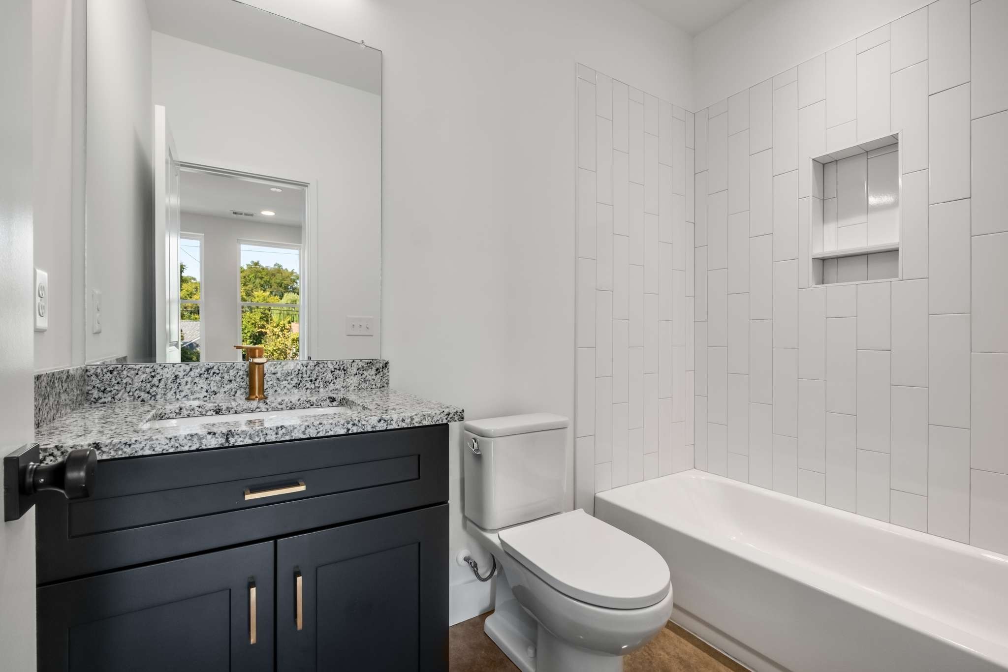 1806 Lischey Avenue, Unit 3 Nashville, TN 37207 - Photo 13 of 25 a bathroom with a granite countertop sink a toilet a mirror and bathtub