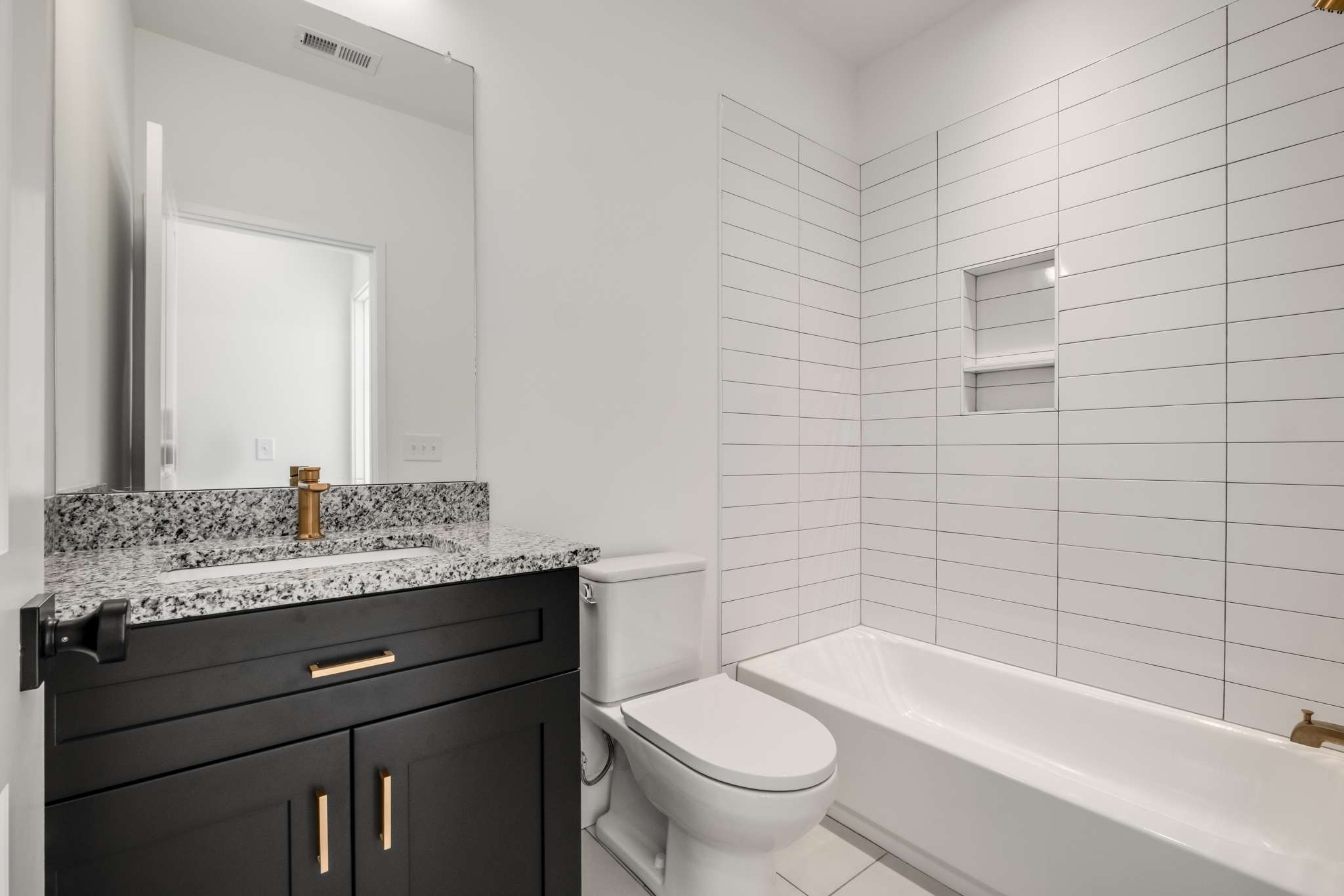 1806 Lischey Avenue, Unit 3 Nashville, TN 37207 - Photo 19 of 25 a bathroom with a granite countertop bathtub sink vanity mirror and toilet