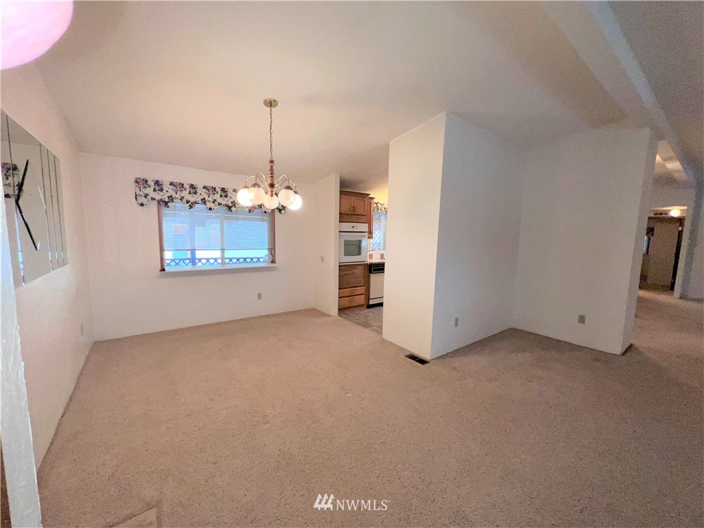 1009 Fir Loop Republic, WA 99166 - Photo 6 of 30 an empty room with chandelier and windows
