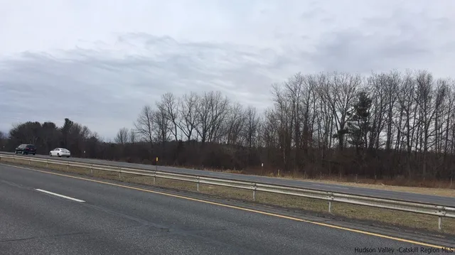 a picture of a room with a white bed and a chair