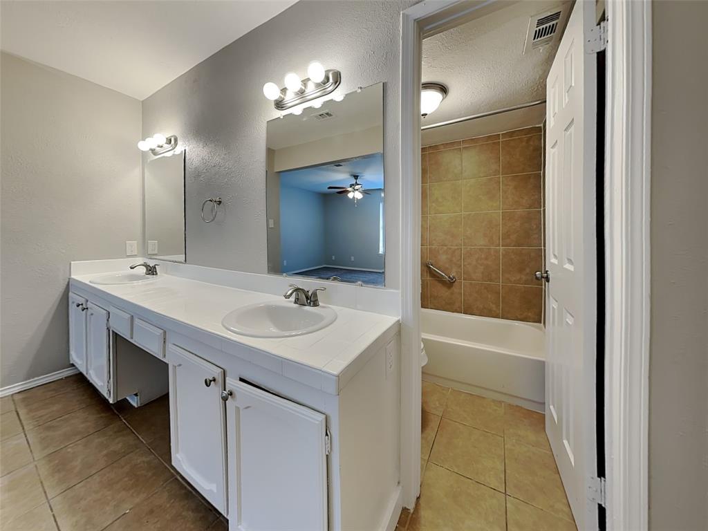 7621 Pebble Beach Drive Rowlett, TX 75088 - Photo 12 of 20 a bathroom with a double vanity sink a mirror and a bathtub