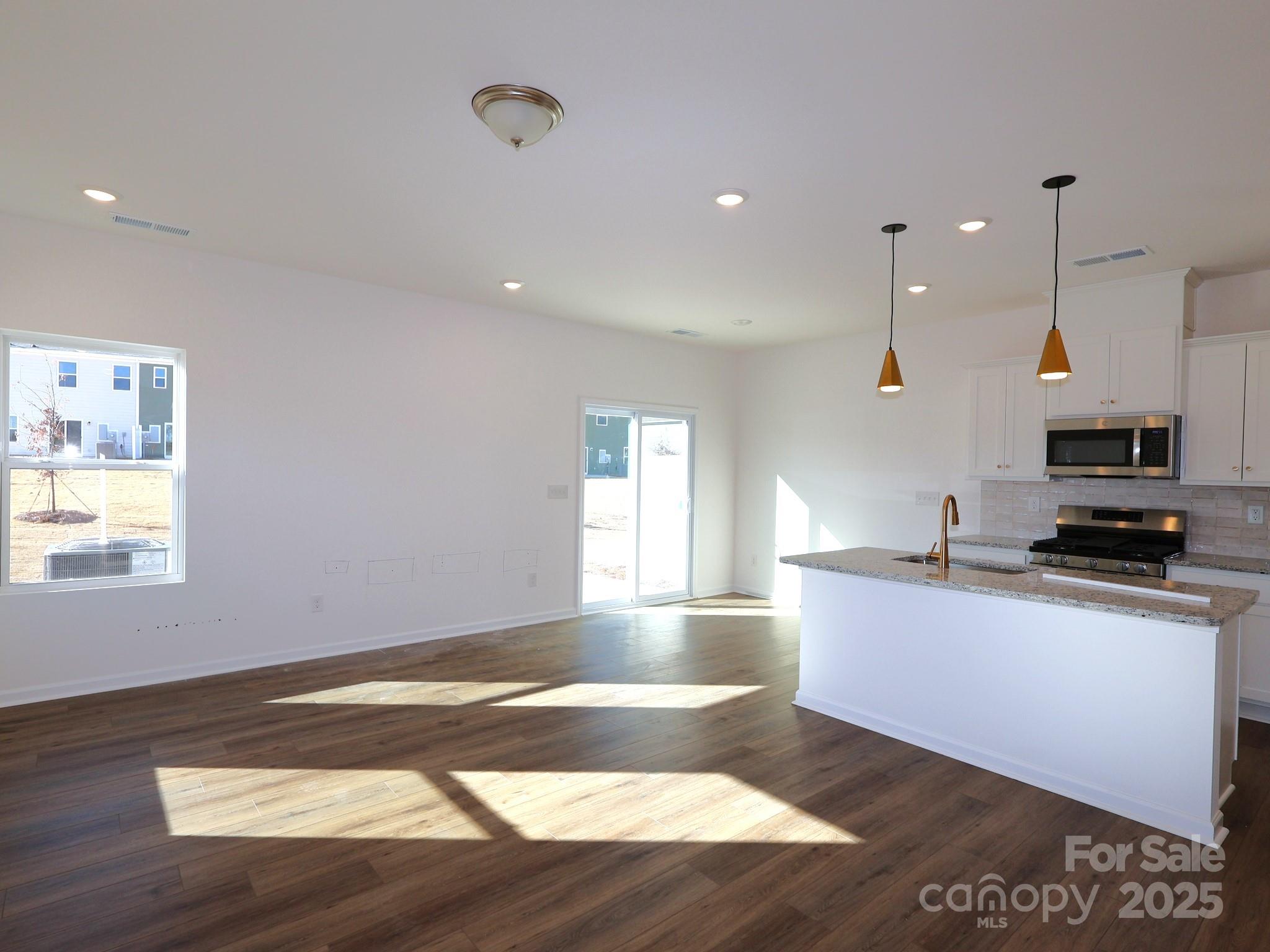 776 Kitfox Drive Northwest Concord, NC 28027 - Photo 6 of 12 a large kitchen with stainless steel appliances a large counter top a stove a sink and a window