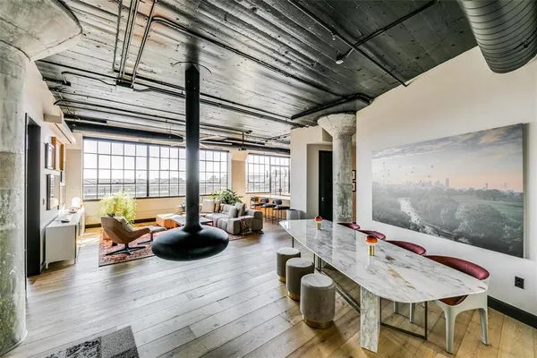 a living room with furniture floor to ceiling window and wooden floor