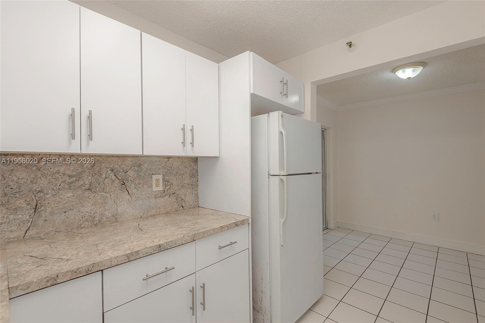 7785 West 30th Court, Unit F104 Hialeah, FL 33018 - Photo 3 of 17 a kitchen with a refrigerator and cabinets