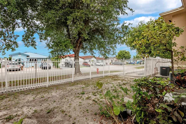 a view of a yard with plants and trees