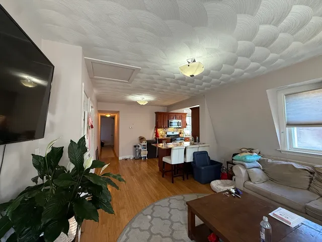 a living room with furniture a flat screen tv and a chandelier