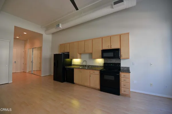 a kitchen with granite countertop a refrigerator and a stove top oven