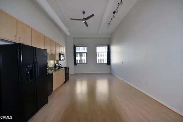 a view of a kitchen with a refrigerator and windows