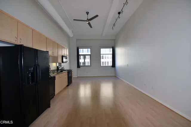 a view of a kitchen with a refrigerator and windows