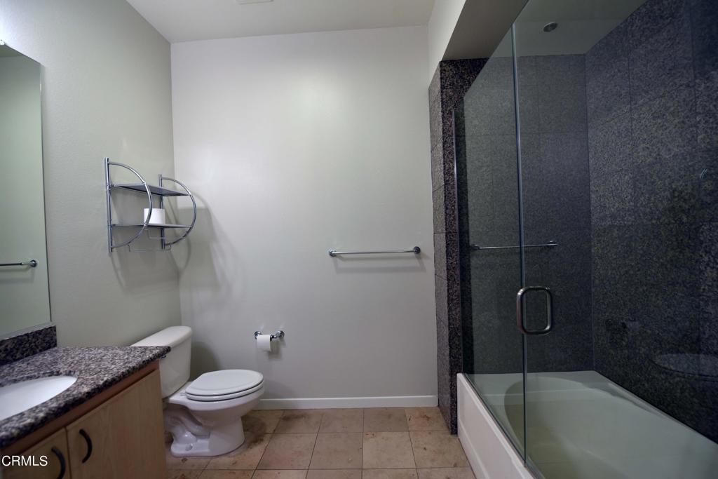 175 South Lake Avenue, Unit 406 Pasadena, CA 91101 - Photo 10 of 12 a bathroom with a granite countertop bathtub shower sink vanity and toilet