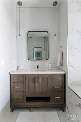 a bathroom with a sink vanity and mirror