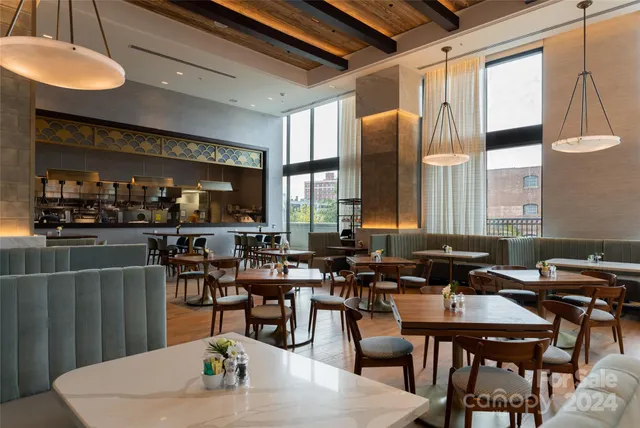a dining room with furniture a large window and a chandelier