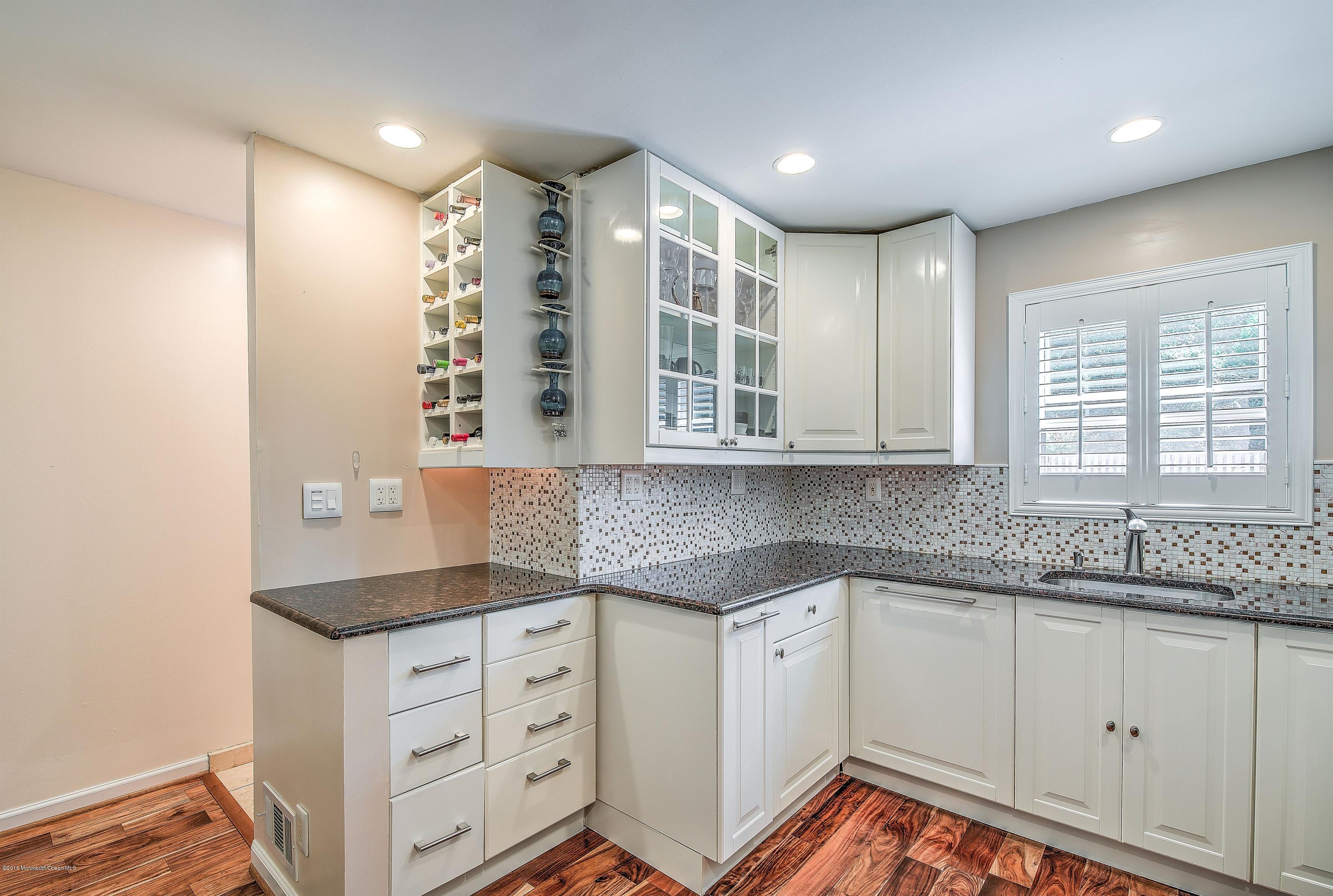 321 Spring Street, Unit 12 Red Bank, NJ 07701 - Photo 14 of 24 a kitchen with granite countertop white cabinets and white appliances