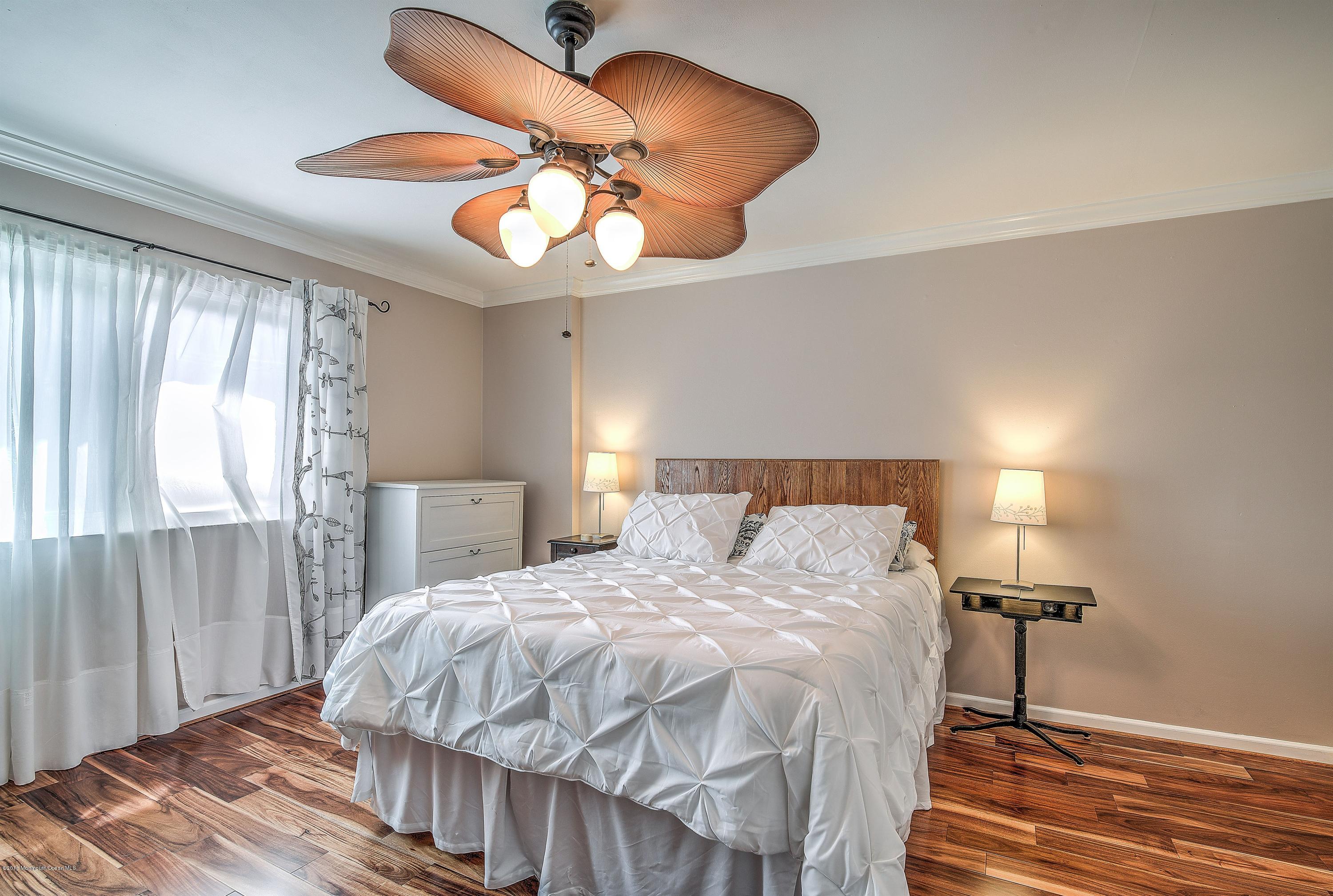 321 Spring Street, Unit 12 Red Bank, NJ 07701 - Photo 16 of 24 a bedroom with a bed and wooden floor