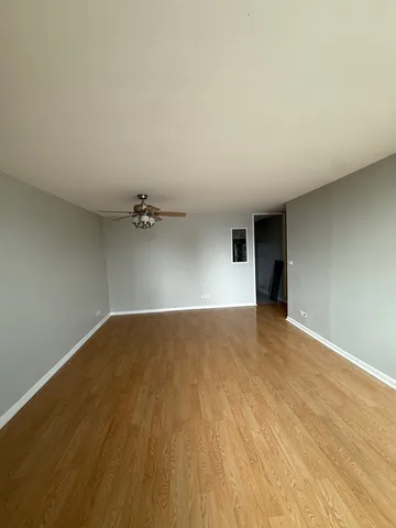a view of empty room with wooden floor