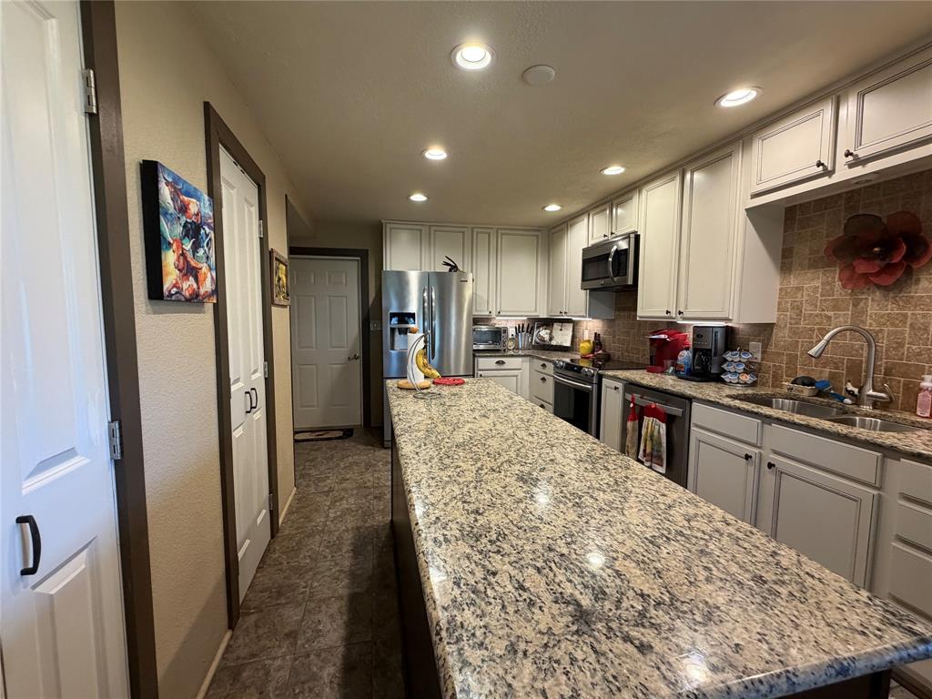 330 South Goode Road Wilmer, TX 75172 - Photo 18 of 38 a kitchen with stainless steel appliances granite countertop a refrigerator and a stove top oven