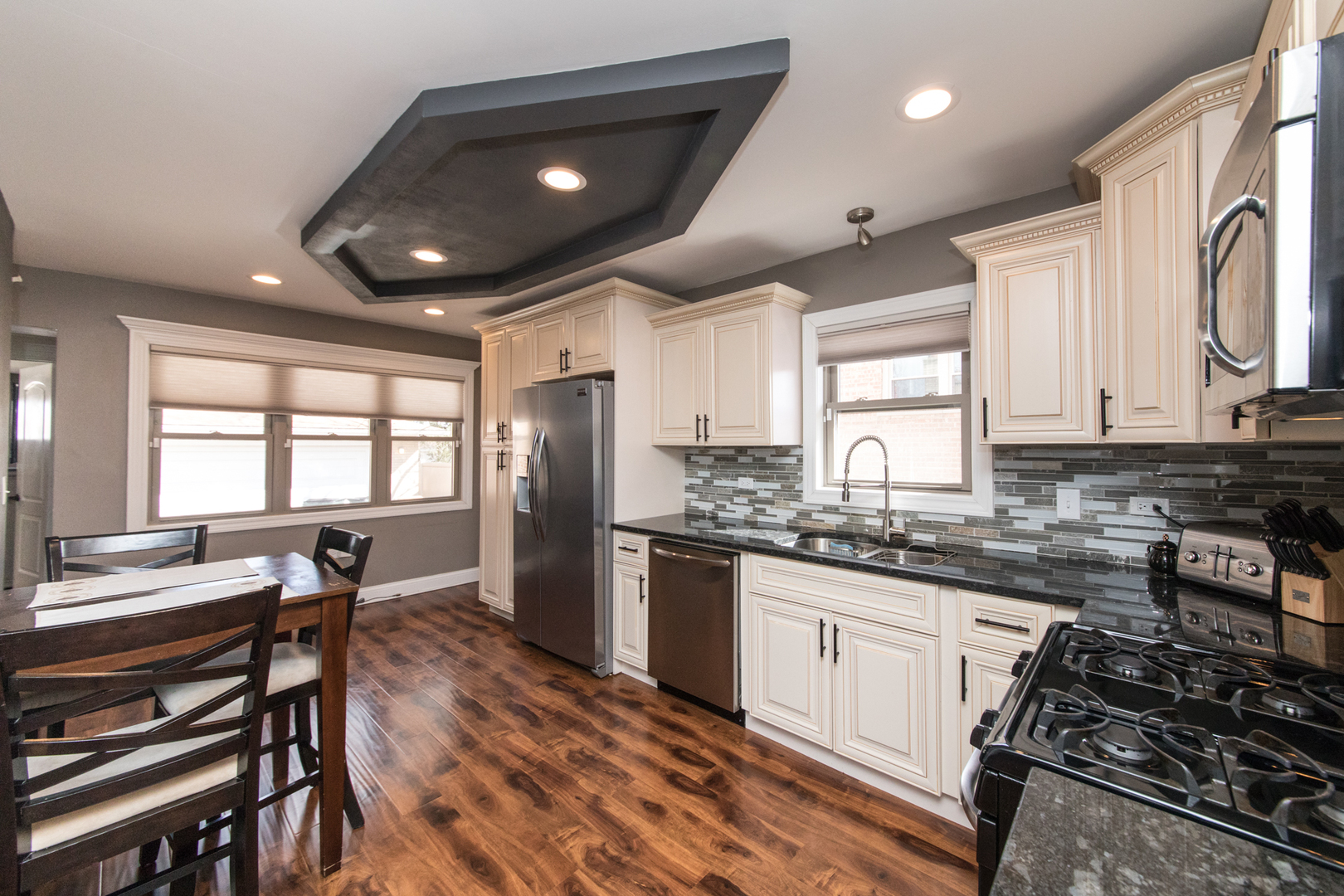 8653 North Merrill Street Niles, IL 60714 - Photo 7 of 19 a kitchen with stainless steel appliances granite countertop sink stove top oven and cabinets