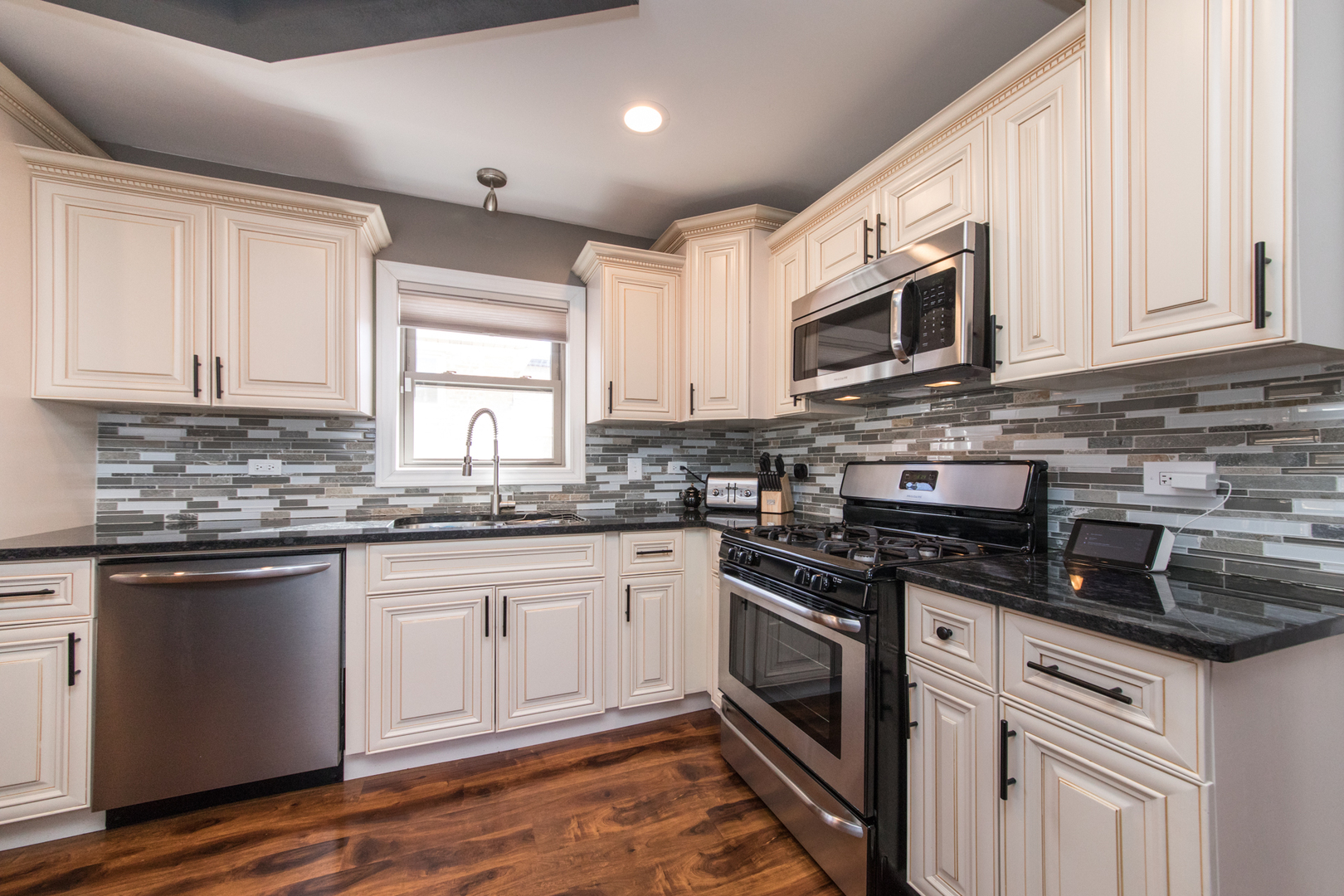 8653 North Merrill Street Niles, IL 60714 - Photo 9 of 19 a kitchen with stainless steel appliances granite countertop a stove sink microwave and cabinets