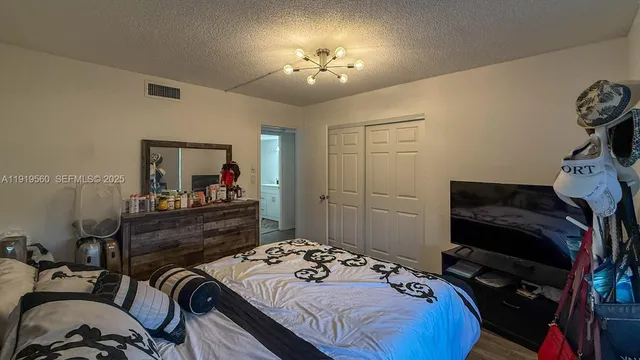 a bedroom with a bed and a mirror on the dresser