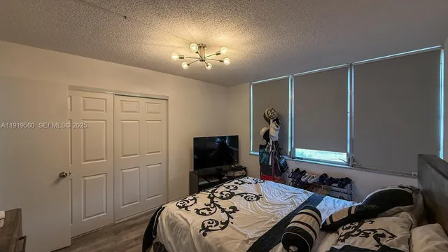 a bedroom with a bed and a chandelier