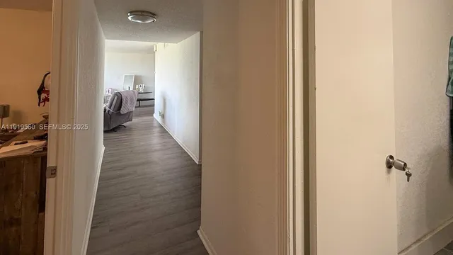 a view of a hallway with wooden floor and closet