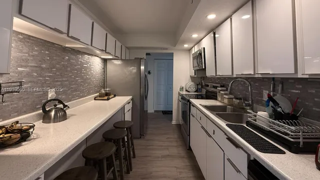 a kitchen with a sink appliances and cabinets