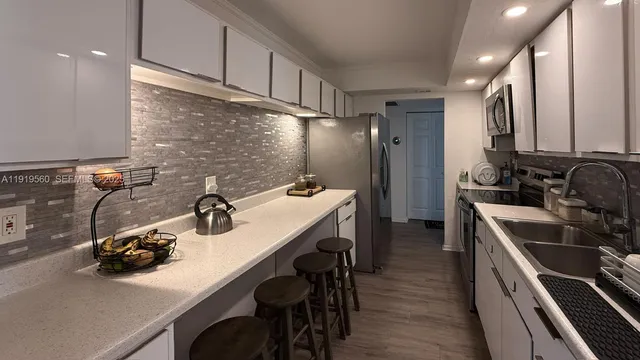 a kitchen with a sink appliances and cabinets