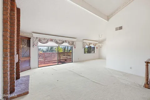a view of an empty room with a fireplace and a window