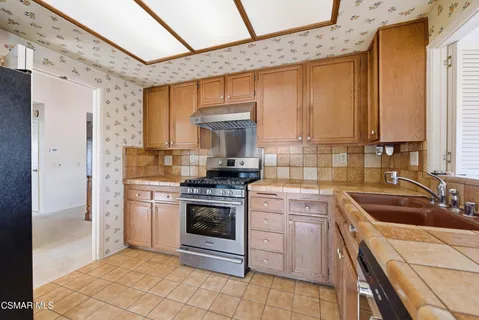 a kitchen with a stove sink and cabinets