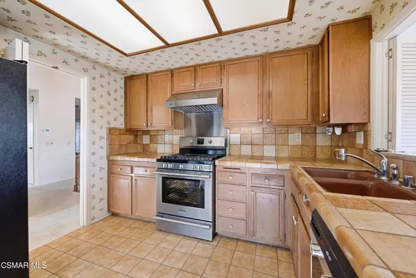 a kitchen with a stove sink and cabinets